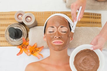 Peaceful brunette getting a mud treatment facial