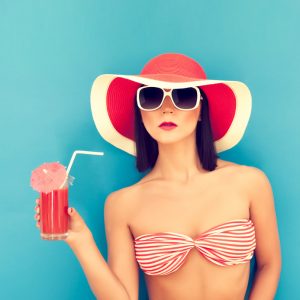 sensual woman with sunglasses drinking a cocktail