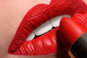 Sensual open mouth  with red tube of lipstick